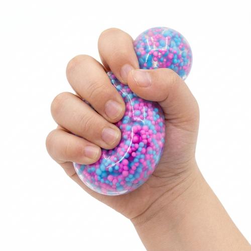 A hand squeezing a clear stress ball filled with pink and blue foam beads, with a second matching stress ball visible in the background, on a white background.