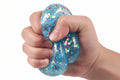 Child squeezing glitter stress ball to reduce anxiety during study time